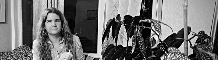 An image of Cass Alexander, the counsellor described in this website, sitting next to a plant.